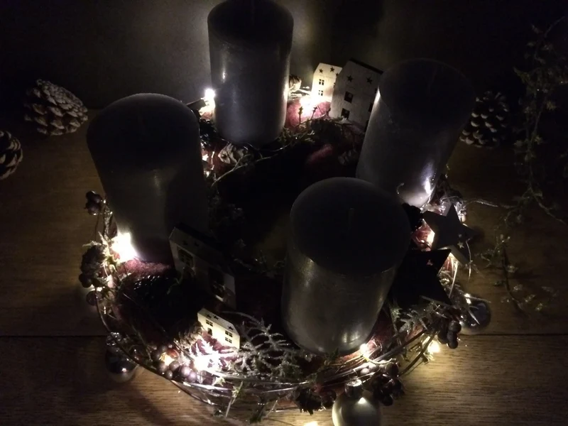 Runder Adventskranz mit Häusern und LED-Lichterkette