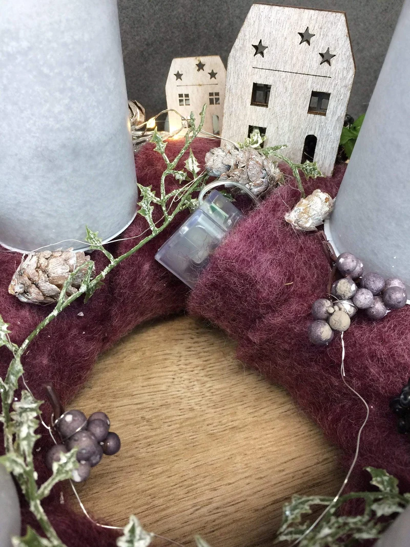 Runder Adventskranz mit Häusern und LED-Lichterkette