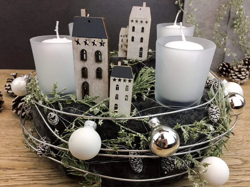 Runder Adventskranz mit Häusern und Naturmaterialien