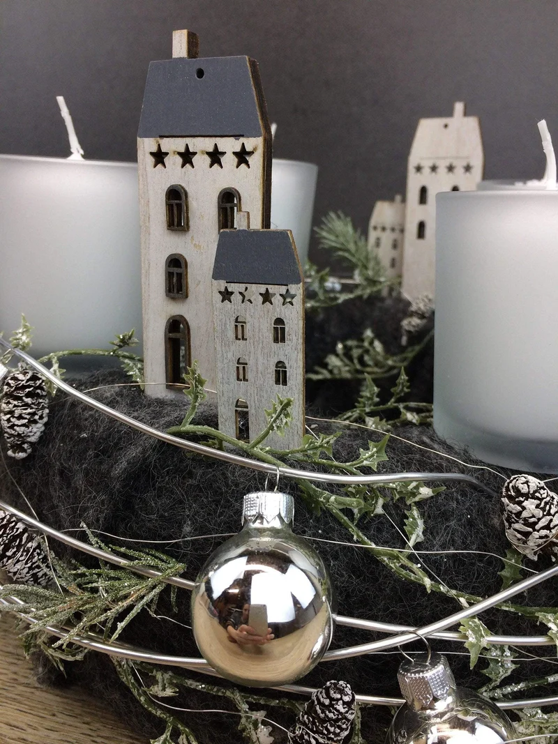 Runder Adventskranz mit Häusern und Naturmaterialien