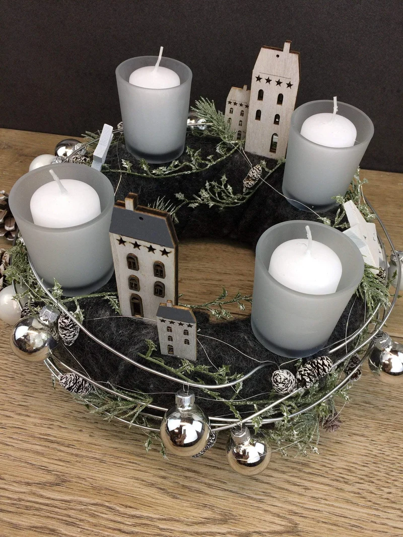 Runder Adventskranz mit Häusern und Naturmaterialien