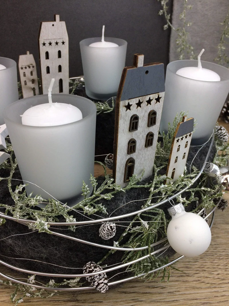 Runder Adventskranz mit Häusern und Naturmaterialien