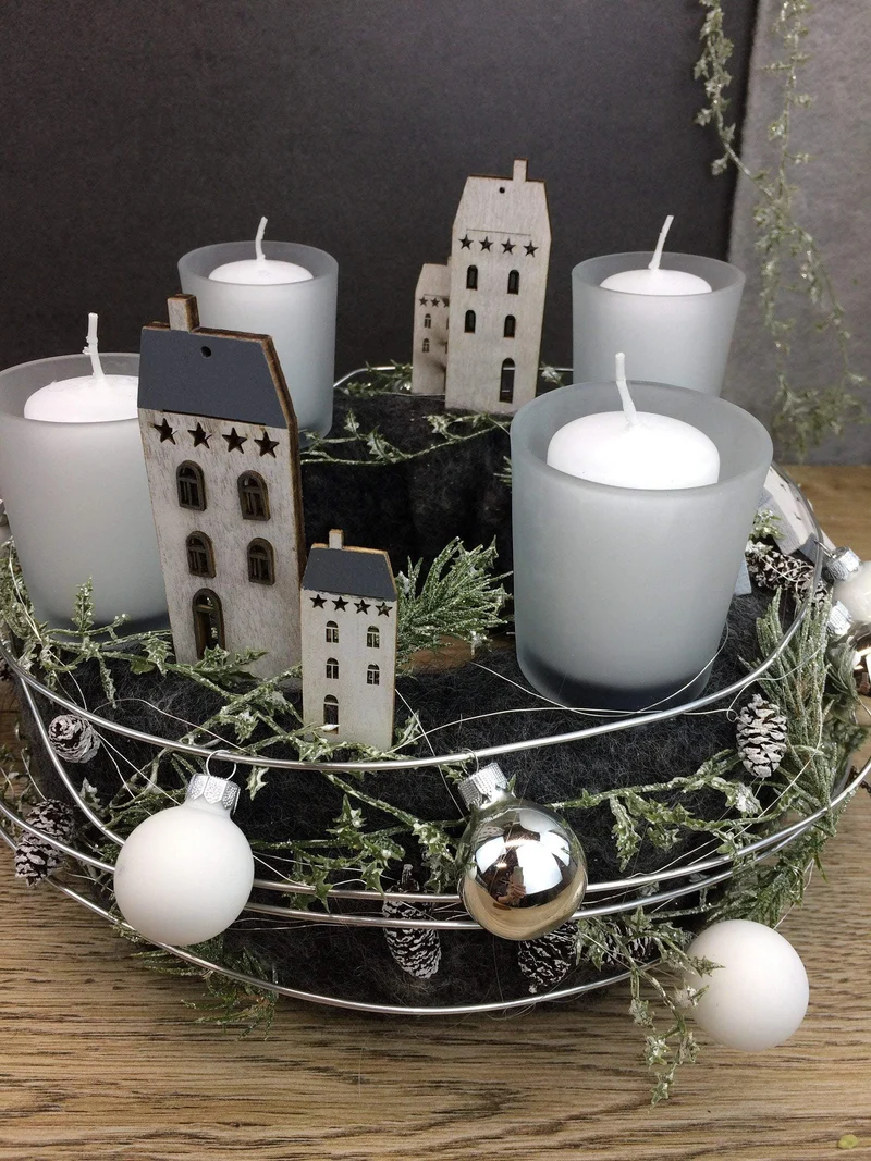 Runder Adventskranz mit Häusern und Naturmaterialien