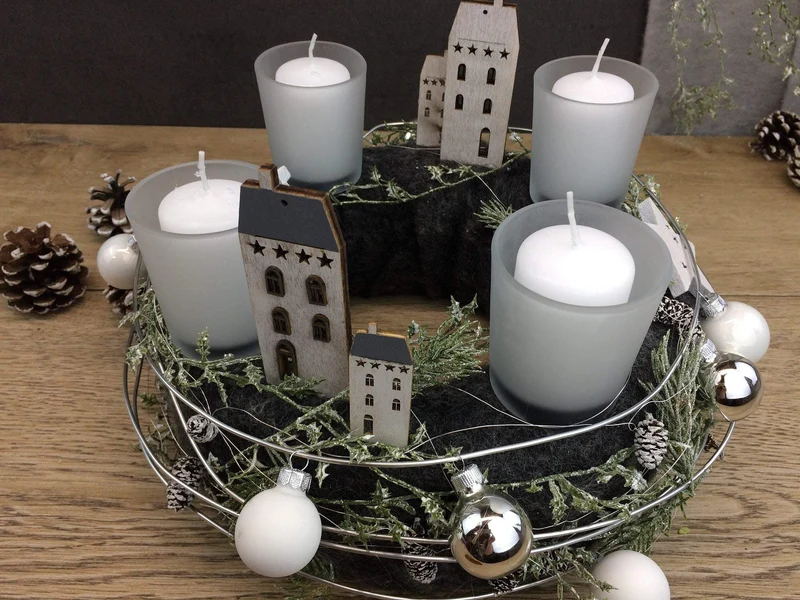 Runder Adventskranz mit Häusern und Naturmaterialien